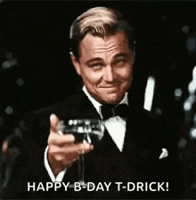 a man in a tuxedo is holding a glass of champagne and making a toast .