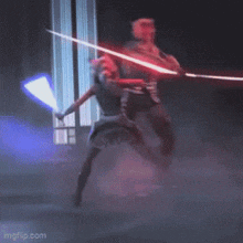 darth maul and ahsoka tano are fighting with lightsabers in a dark room .