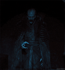 a man in a fur coat is standing in the dark with the name animusrox on the bottom left