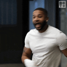 a man in a white t-shirt with the word be on it