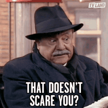 a man wearing a hat and coat says that doesn 't scare you