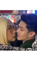 a man and a woman are kissing and the woman is wearing glasses