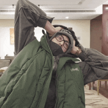 a person wearing glasses and a green vest that says ' xtreme ' on it
