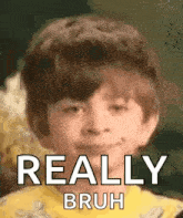 a young boy is making a funny face with the words `` really bruh '' .