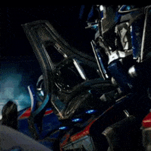 a man is looking at a blue robot with a helmet on .