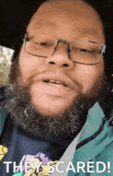 a man with glasses and a beard has the words they scared on his face