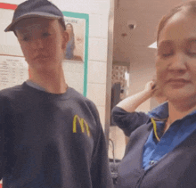 a man in a mcdonald 's sweatshirt stands next to a woman
