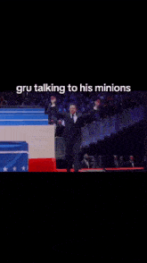 a man in a suit is dancing on a red carpet with a caption that says gru talking to his minions .