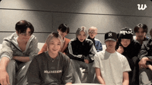 a group of people are sitting on a couch and one of them has a ny hat on