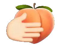 a hand holding a peach with leaves on it