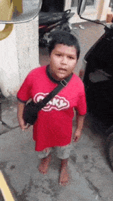 a boy wearing a red shirt that says sky