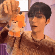 a man is holding up a stuffed animal with the number 2 on it