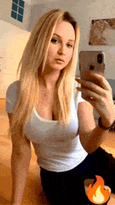 a woman in a white shirt is taking a selfie