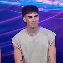 a man in a white shirt is smiling in front of a purple and blue background