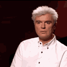a man wearing a white shirt with black buttons