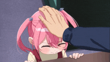 a little girl with pink hair is being patted on the head