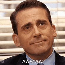 a man in a suit and tie is making a funny face and saying awwww .