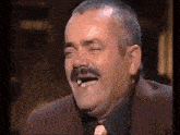 a man with a mustache is laughing with his eyes closed and his mouth open .